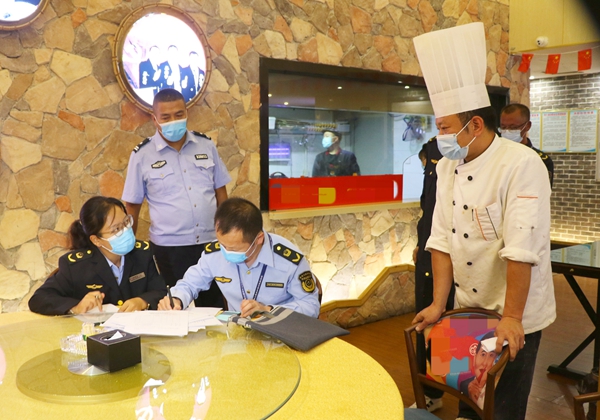 图为执法人员撰写餐饮单位责令改正通知书。_副本.jpg ""